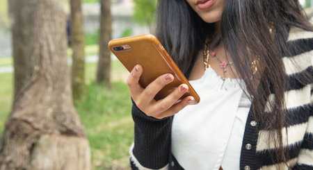 Young woman using mobile phone outdoors.