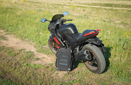 Backpack with a motorcycle outdoors. Ready for adventure and travelの写真素材