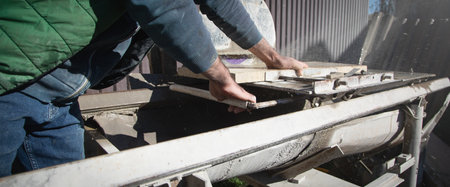 electric tile cutter. Tiler cutting tile on wet saw machine