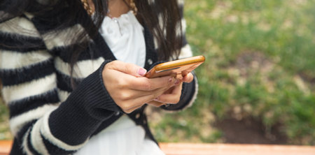 Young woman using mobile phone outdoors.の写真素材