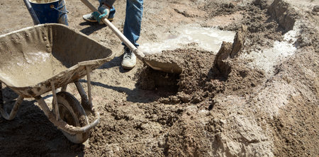 Worker prepare concrete with shovel at construction site.の写真素材