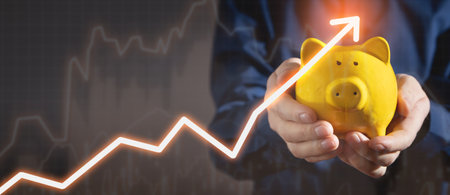 Man holding piggy bank with a growth graph.の写真素材