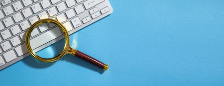 Magnifying glass on the computer keyboard.の写真素材