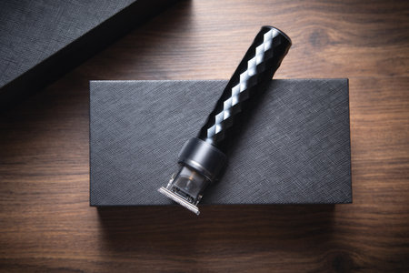 Black hair trimmer on wooden background.