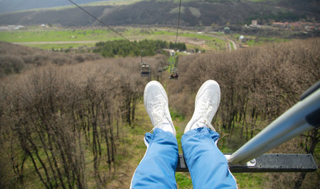man sitting in a ropeway. Male sneakersの写真素材