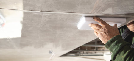 Electrician checking lighting to the ceiling in the home.