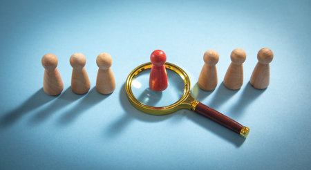 Magnifying glass and wooden human figures. management. Candidate selectionの写真素材
