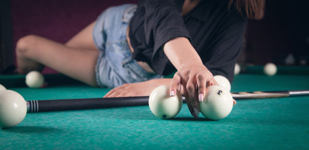 Caucasian young girl playing billiards.