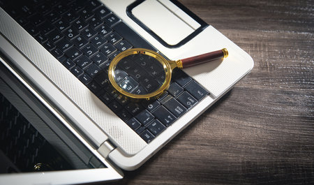 Magnifying glass on the computer keyboard.