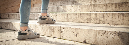 Young woman walking up the stairs in the city.
