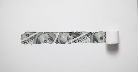 Hole ripped in paper with a dollar.の写真素材