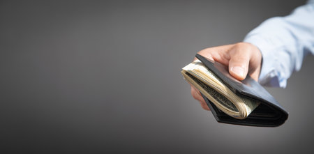 Businessman holding dollars with wallet.