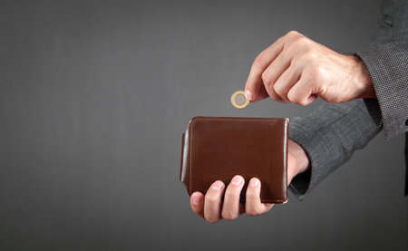 Man putting coin into his wallet.
