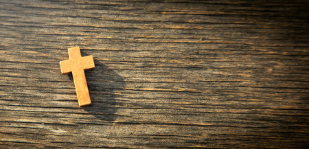 Christian cross on the wooden background.