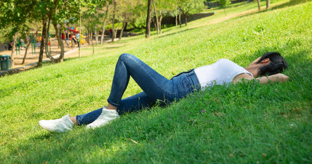Caucasian girl lying on the grass at the outdoor.