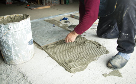 Worker using spatula and putting glue on floor.の写真素材