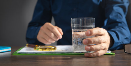 Caucasian businessman holding glass of water.