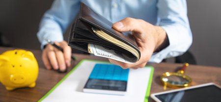 Businessman holding dollars with wallet.
