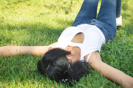 Caucasian girl lying on the grass at the outdoor.