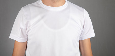 Man in a white t-shirt at gray background.