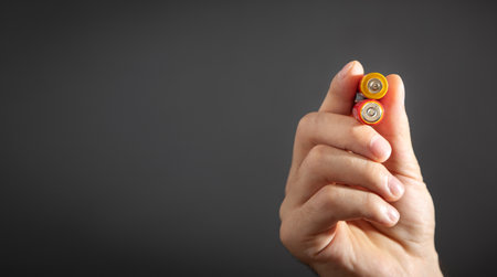 Male hand showing alkaline batteries.の写真素材