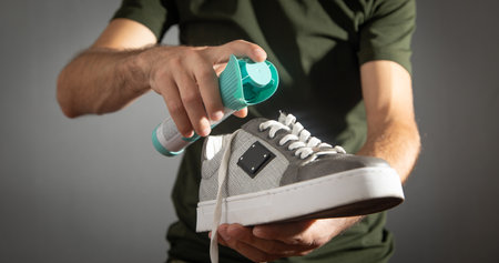 Man using antibacterial spray against unpleasant odors.