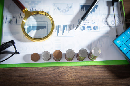 Stack of coins on financial graphs.