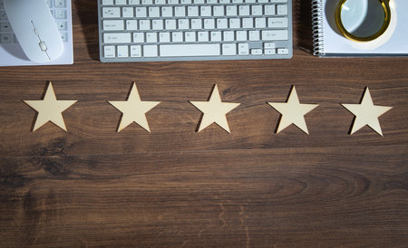 Wooden 5 stars with a business object on the table. Increase rating