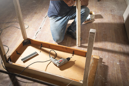 Caucasian carpenter repairing broken table.の写真素材