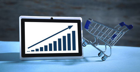 Shopping cart, tablet and growth graph. Increase in sales