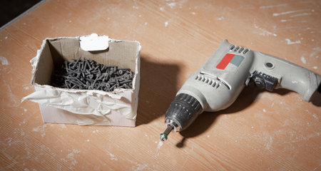 Drill with screws on the table.