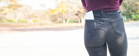 girl with mobile phone in pocket.