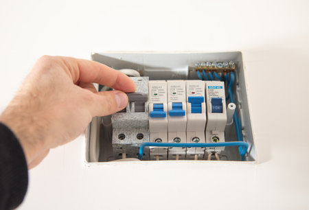Male hand switching electric board at home.