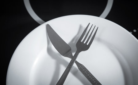 Plate with a fork and knife on the kitchen table.