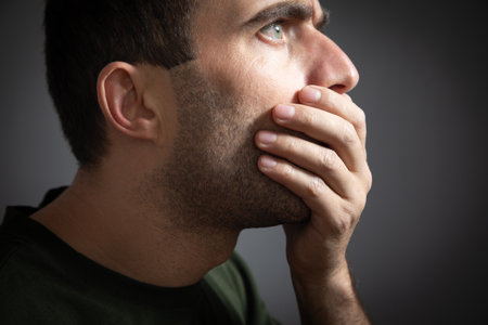 Caucasian man covering his mouth with hand. secret