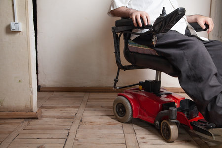 Disabled man using joystick in electric wheelchair.の写真素材