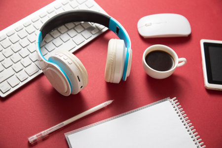 White wireless headphones and other objects on the bordeaux background.の写真素材