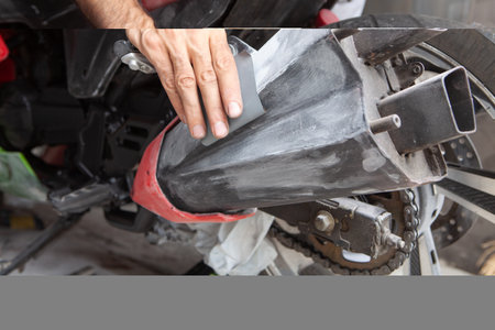 Preparation for painting a motorcycle. Hand in a sandpaperの写真素材