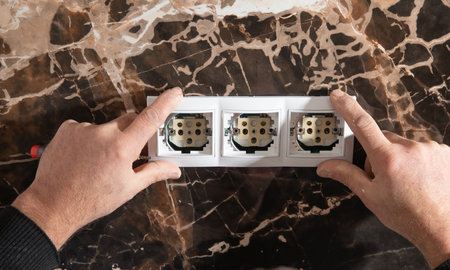 Electrician installing a wall socket at home.の写真素材