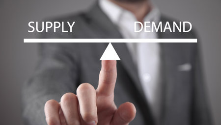 Man showing supply and demand word balance scales. Business conceptの写真素材