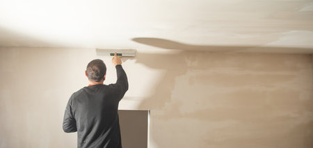 Worker is applying putty on a wall. Renovating houseの写真素材