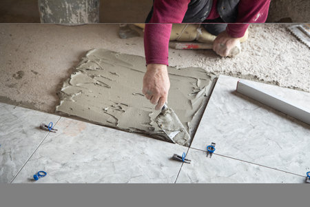 Laying floor ceramic tile. Renovating the floorの写真素材