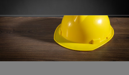 Yellow construction helmet on the wooden table.の写真素材