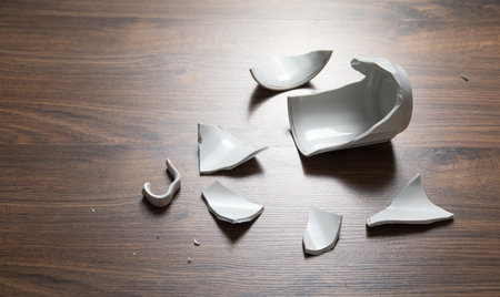 White broken cup on the wooden background.の写真素材