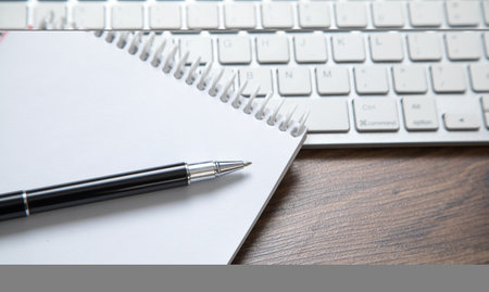Pen and notepad on the computer keyboard.の写真素材
