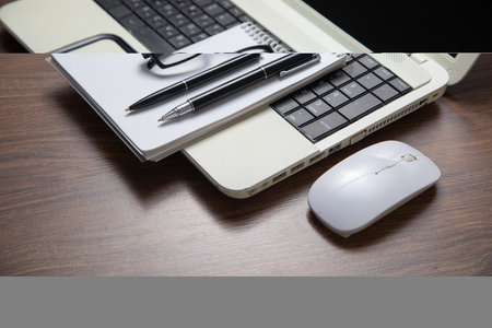 Pen and notepad on the computer keyboard.の写真素材