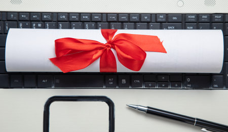Diploma, pen on the laptop keyboard.の写真素材
