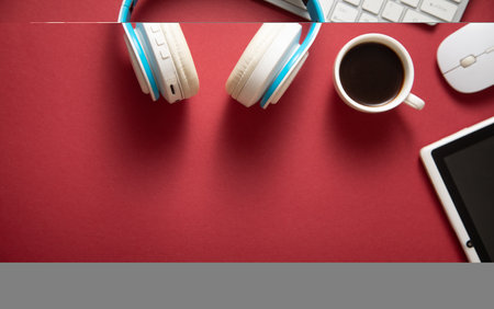 White wireless headphones and other objects on the bordeaux background.の写真素材