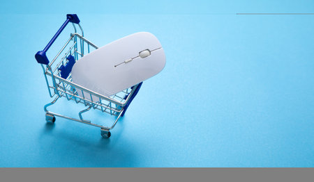 Shopping cart and computer mouse on the blue background.の写真素材