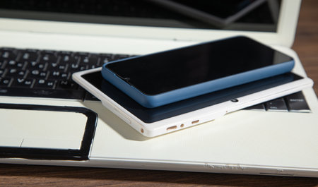 Smartphone, tablet, laptop computer on the wooden table.